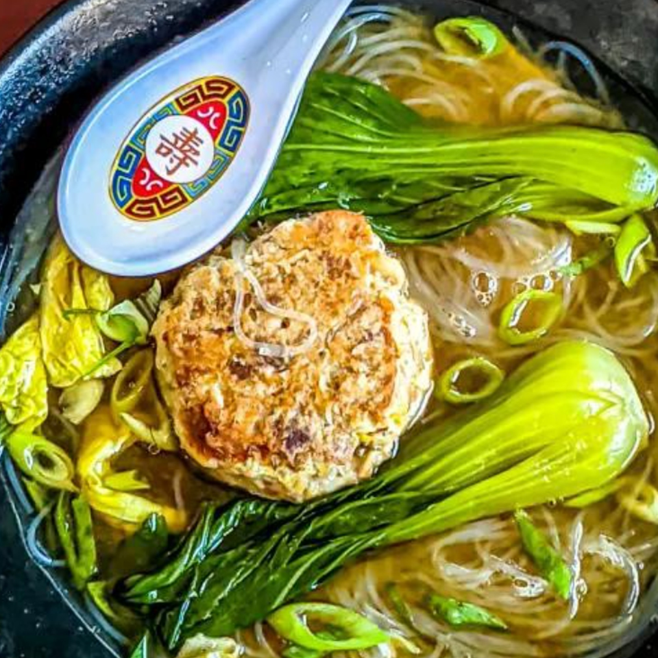 Close-up of a bowl of Jack's Bao ramen with a large meatball, bok choy, and noodles.
