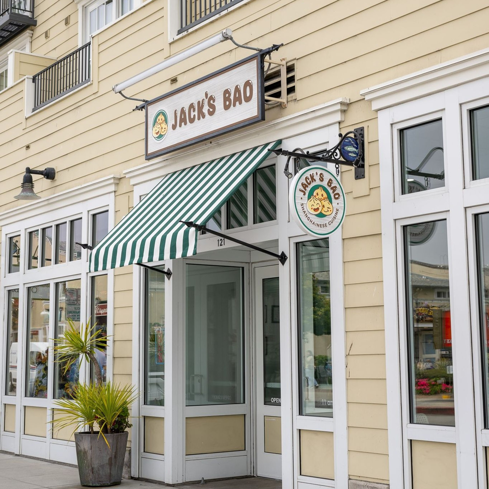 Jack's Bao restaurant exterior with a green and white striped awning and two signs.